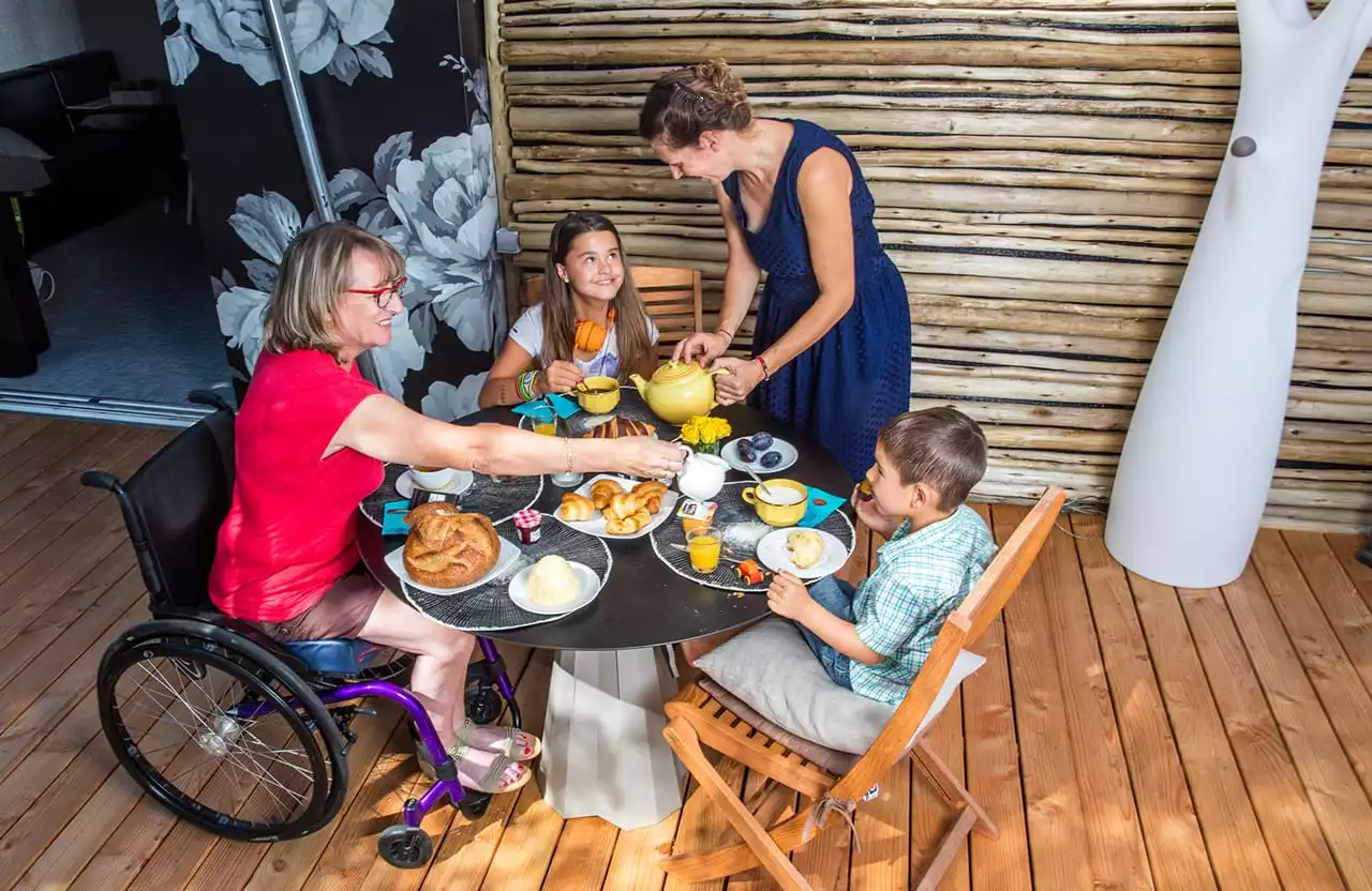 une famille qui prennent leur petit déjeuner sur la terrasse du mobil-home pmr