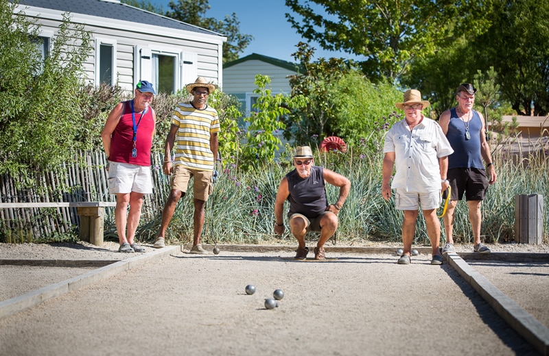 un groupe de vacanciers qui joue à la pétanque